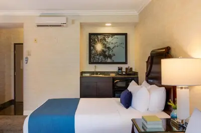 a hotel room with a bed and a sink at Ayres Suites Diamond Bar in Diamond Bar