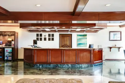 an office lobby with a large wooden reception desk at Ayres Suites Diamond Bar in Diamond Bar