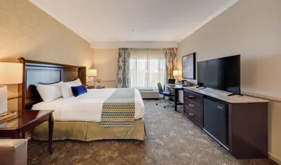 a hotel room with a bed and a flat screen tv at Ayres Hotel Corona - Riverside in Corona