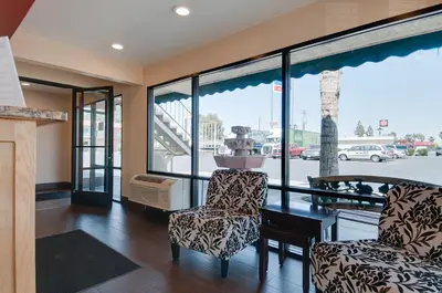 a living room with a table and two chairs at Vagabond Inn Bakersfield South in Bakersfield