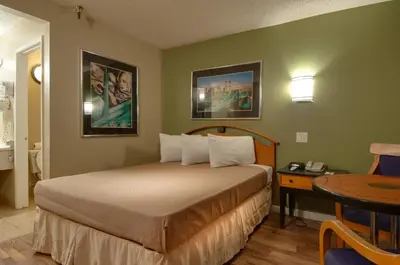a hotel room with a bed and a table at Vagabond Inn Bakersfield South in Bakersfield