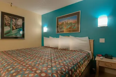 a bedroom with a bed and a blue wall at Vagabond Inn Bakersfield North in Bakersfield