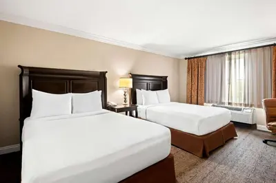 a hotel room with two beds and a chair at Best Western Ontario Mills Mall in Ontario