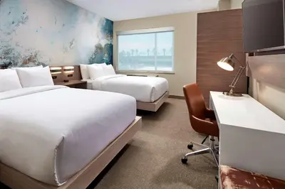 a hotel room with two beds and a desk at Anaheim Resort Suites in Anaheim