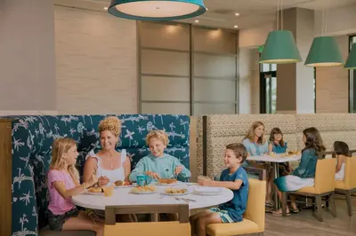 a group of people sitting at tables in a restaurant at Anaheim Resort Suites in Anaheim