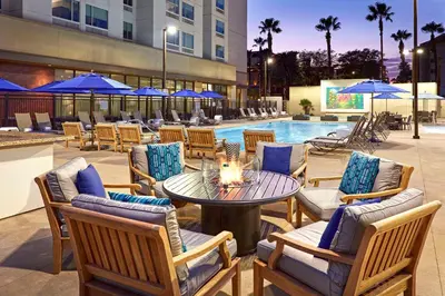 a patio with a table and chairs and a pool at Anaheim Resort Suites in Anaheim