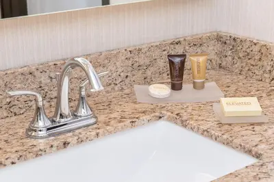a bathroom counter with a sink and some products on it at Ayres Suites Yorba Linda/Anaheim Hills in Anaheim