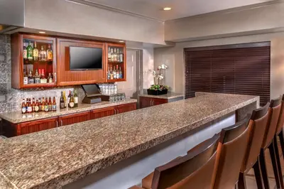 a bar in a hotel room with a counter and chairs at Ayres Suites Yorba Linda/Anaheim Hills in Anaheim