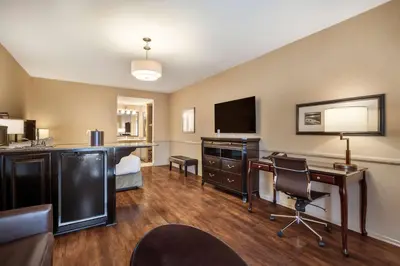 a hotel room with a bed and a desk with a computer at Best Western Corona Hotel & Suites in Corona