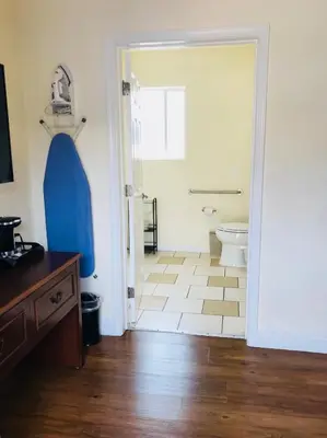 a bathroom with a toilet and a blue doorway at Bella Capri Inn and Suites in Camarillo