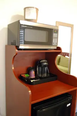 a microwave sitting on top of a wooden cabinet at Bella Capri Inn and Suites in Camarillo