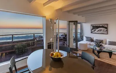 a living room with a table and a view of the ocean at Malibu Beach Home Private Sandy Beach and Surf in Malibu
