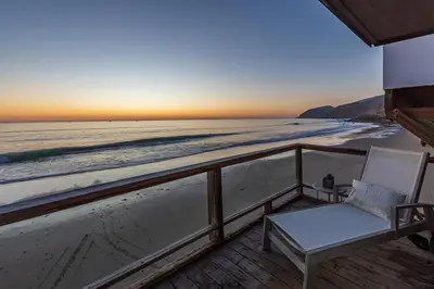 a balcony with a chair and a view of the beach at Malibu Beach Home Private Sandy Beach and Surf in Malibu