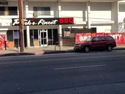 a red car parked in front of a building at Knights Inn Los Angeles Central / Convention Center Area in Los Angeles