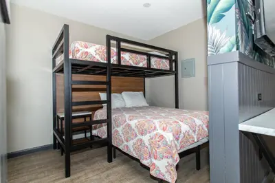 a small room with a bunk bed and a bed and a bunk bed at Magnolia Tree Hotel-Maingate/Anaheim Convention Center in Anaheim