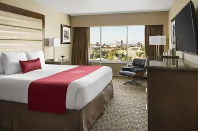a hotel room with a large bed and a large window at USC Hotel in Los Angeles