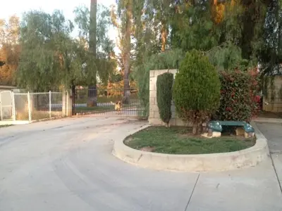 an empty street with a tree and a fence at All 8 Motel in Azusa