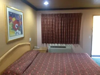 a hotel room with a bed and a window at All 8 Motel in Azusa
