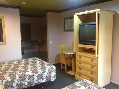 a bedroom with a bed and a tv and a dresser at All 8 Motel in Azusa