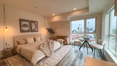 a bedroom with a large bed and a table at Lovely Studio in heart of Hollywood in Los Angeles