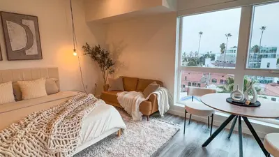 a bedroom with a bed and a table and a window at Lovely Studio in heart of Hollywood in Los Angeles