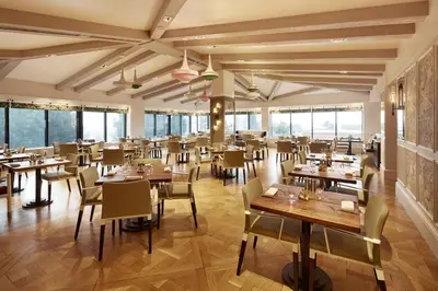 a restaurant with tables and chairs and windows at The London West Hollywood at Beverly Hills in Los Angeles