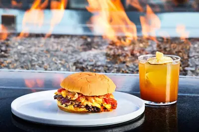 a sandwich on a plate next to a drink at AC Hotel by Marriott Los Angeles South Bay in Los Angeles
