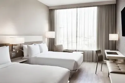 a hotel room with two beds and a couch at AC Hotel by Marriott Los Angeles South Bay in Los Angeles