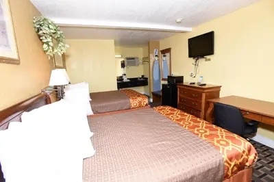 a hotel room with two beds and a desk at Best Budget Inn Anaheim in Anaheim