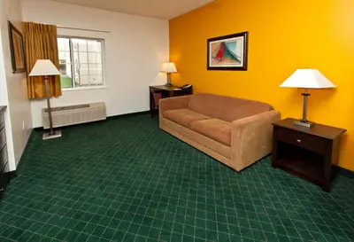 a living room with a couch and a window at Landmark Inn Fort Irwin in Fort Irwin