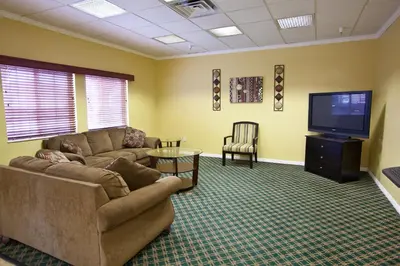 a living room with a couch and a tv at Landmark Inn Fort Irwin in Fort Irwin