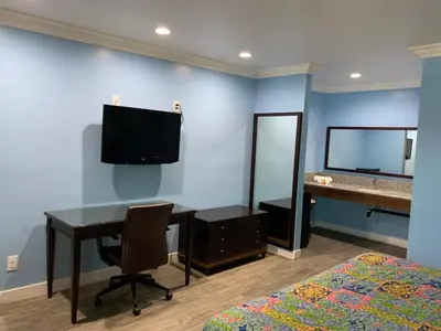 a bedroom with a desk and a bed and a mirror at Redondo Beach Motel - LAX in Gardena