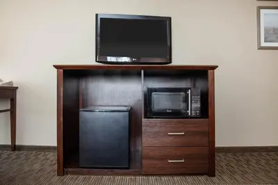 a microwave and a tv on top of a wooden stand at La Quinta by Wyndham Inglewood in Inglewood