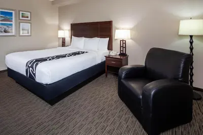 a hotel room with a bed and a chair at La Quinta by Wyndham Inglewood in Inglewood