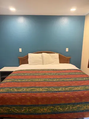 a bedroom with a bed with a blue wall at Anaheim National Inn in Anaheim