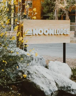 a sign in front of a building with some rocks at Noon Lodge in Big Bear Lake