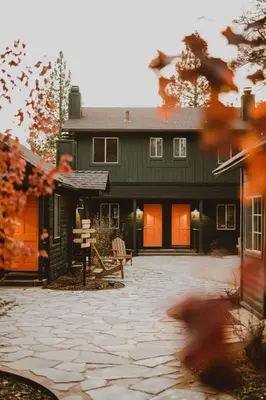 a large green house with a patio in front of it at Noon Lodge in Big Bear Lake