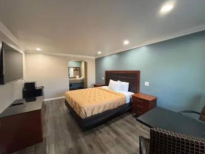 a hotel room with a bed and a table at Economy Inn - Burbank Airport in Sun Valley