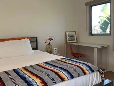 a bedroom with a bed and a desk and a window at The M Malibu in Malibu