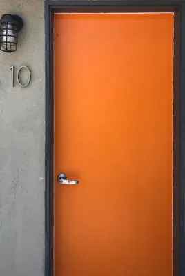 an orange door to a building with the number at The M Malibu in Malibu