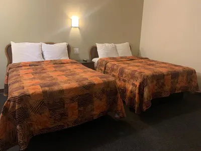 a hotel room with two beds and a lamp at Ventura Beach House Motel in Ventura