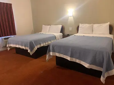 two beds in a small room with two beds sidx sidx sidx at Ventura Beach House Motel in Ventura