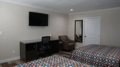 a hotel room with two beds and a desk and a computer at Sea Breeze Inn - LAX Airport, Los Angeles in Inglewood