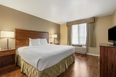 a hotel room with a bed and a flat screen tv at Best Western Plus John Jay Inn & Suites in Palmdale