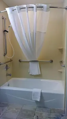a bathroom with a bath tub with a shower curtain at Microtel Inn & Suites by Wyndham Wheeler Ridge in Wheeler Ridge