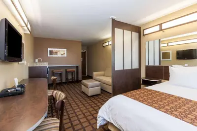a hotel room with a bed and a desk at Microtel Inn & Suites by Wyndham Wheeler Ridge in Wheeler Ridge