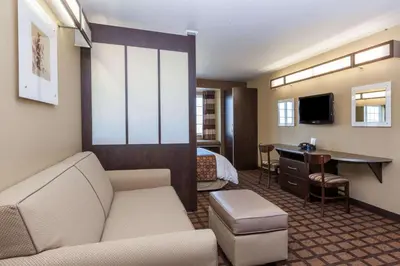 a hotel room with a couch and a bed and a desk at Microtel Inn & Suites by Wyndham Wheeler Ridge in Wheeler Ridge