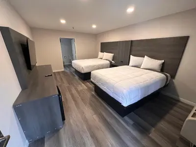 a hotel room with two beds and a flat screen tv at Five Star Inn in West Covina