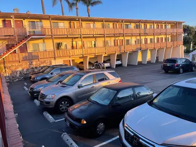 a row of cars parked in a parking lot in front of a hotel at Seahorse Inn Manhattan Beach - LAX in Manhattan Beach