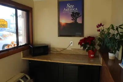 a kitchen with a counter with a television and plants at Travelodge by Wyndham Buena Park in Buena Park